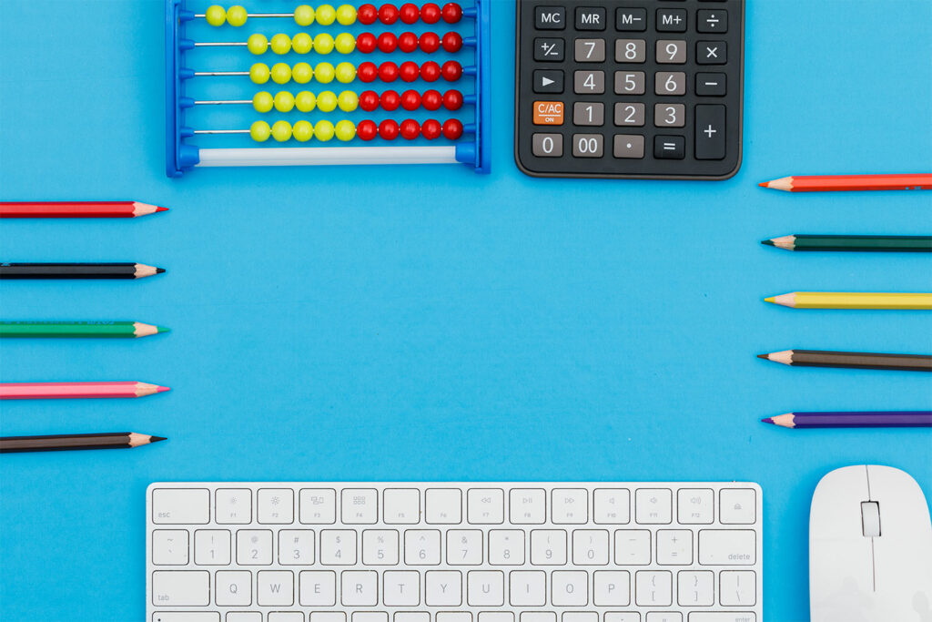 back school concept with pencils keyboard mouse calculator abacus blue background flat lay